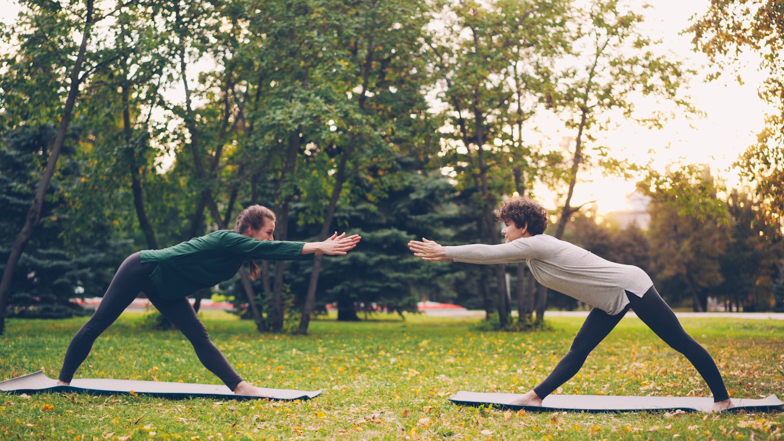 Two people doing yoga in a park