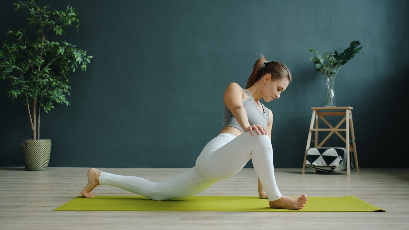 Woman stretching on yoga mat indoors